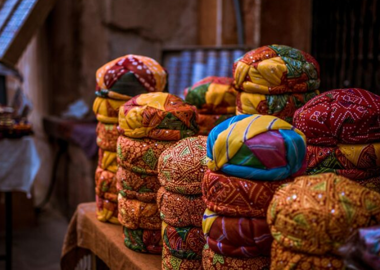 Traditional Rajasthani turbans on display in Jaipur market Colorful pagdi collection at Hawa Mahal Jaipur Handcrafted turbans sold in Rajasthan street market Jaipur palace market with traditional Rajasthani headgear Brightly patterned Rajasthani pagdis in local bazaar Decorative turbans stacked in Jaipur market stall Handmade Rajasthani pagris near Hawa Mahal Rajasthan Colorful headgear market outside Jaipur Palace of Winds Indian traditional turbans in vibrant colors for sale Rajasthani cultural turbans displayed in Jaipur Rajasthan market