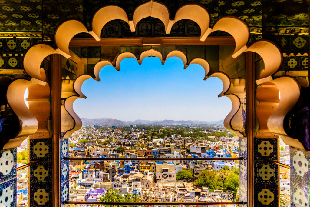 Udaipur city view, City Palace Udaipur, lake city Rajasthan, palace window view, Udaipur travel guide, romantic city India, royal Rajasthan view, Udaipur tourist spot, historic palace Rajasthan, lakeside heritage city