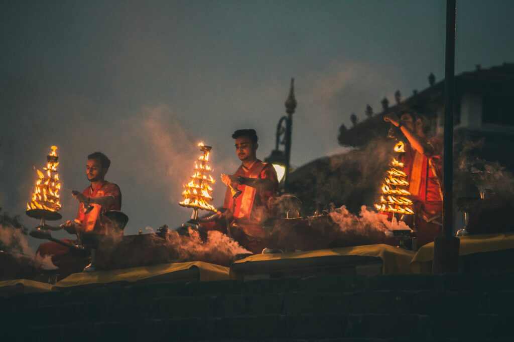 Ganga Aarti Ceremony Hindu Priests Fire Night Puja Ritual Indian Religious Ceremony Aarti Flame Worship Varanasi Ghat Ritual (Likely location) Devotional Fire Ritual Pooja Darkness Smoke Traditional Hindu Worship Aarti Lamps Offering
