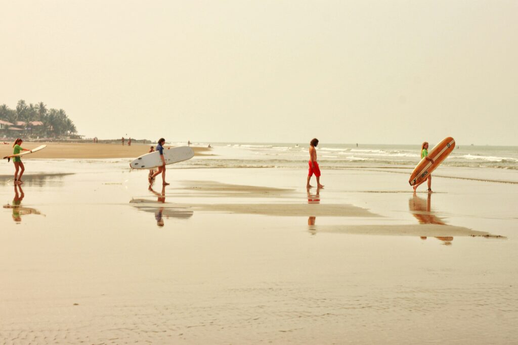 Surfers Walking Beach Surfboards Wet Sand Tropical Beach Surfing Goa Beach Surfers (Assuming location) People Carrying Boards Low Tide Surfing Beach Reflections Surf Coastal Surfing Lifestyle Water Sports Beach Surfing Lesson Beach